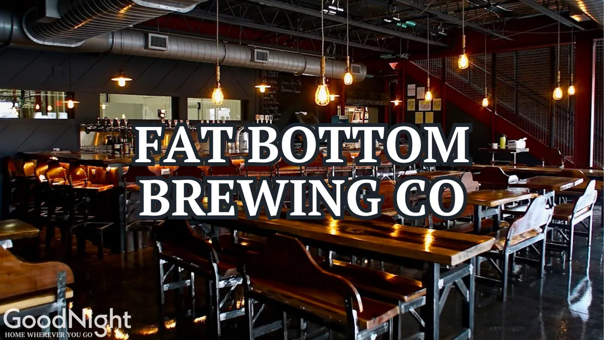 An inviting interior of a brewery or bar, featuring long wooden tables, stylish lighting, and a visible bar area. People can be imagined socializing, tasting craft beers, and enjoying the casual, friendly ambiance typical of Nashville’s brewery scene.